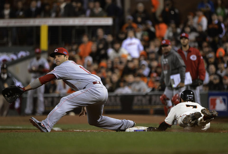 Gregor Blanco #7 of the San Francisco Giants dives to beat out a bunt and throw to Joey Votto #19 of the Cincinnati Reds during the sixth inning in Game One of the National League Division Series at AT&T Park on October 6, 2012 in San Francisco, California. (Photo by Thearon W. Henderson/Getty Images)