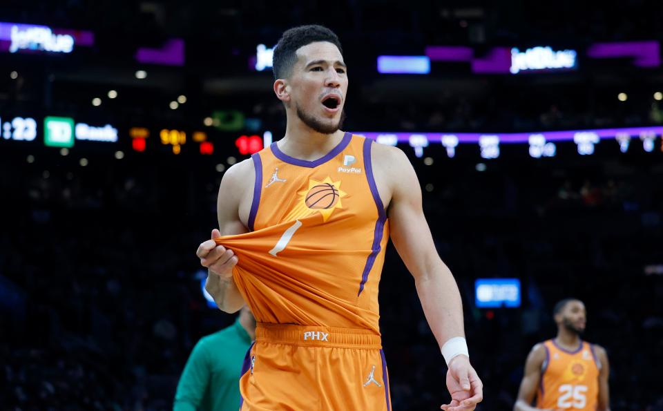   Phoenix Suns guard Devin Booker (1) complains about a call before being called for a technical foul during the first half of an NBA basketball game against the Boston Celtics, Friday, Dec. 31, 2021, in Boston. (AP Photo/Mary Schwalm)