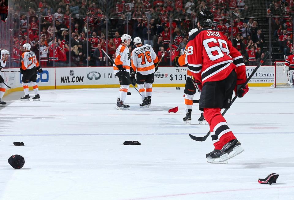 Jaromir Jagr of the New Jersey Devils skates toward the bench as fans throw hats onto the ice after Jagr scored a hat trick against the Philadelphia Flyers n January 3, 2015 at the Prudential Center in Newark, New Jersey (AFP Photo/Elsa)