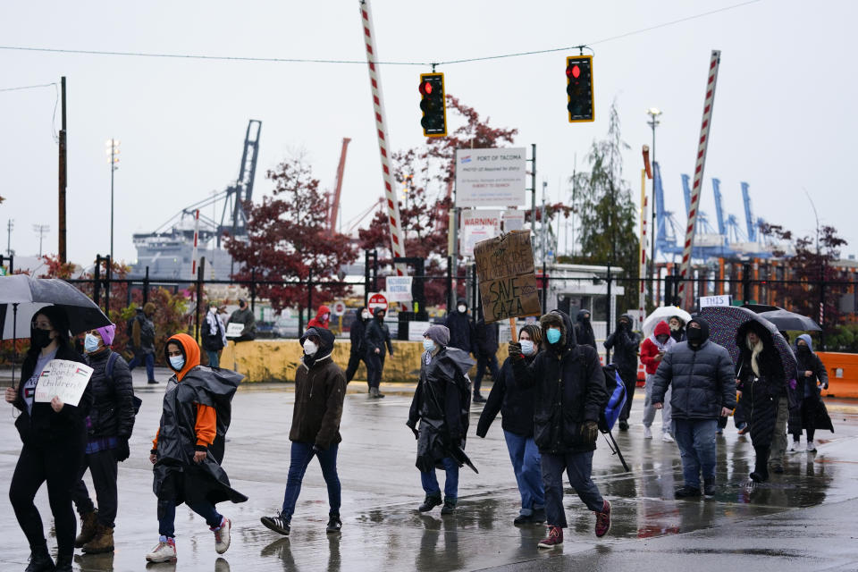 People march in a circle as hundreds of protesters block the Port of Tacoma entrances to delay the loading of the Cape Orlando vessel, Monday, Nov. 6, 2023, in Tacoma, Wash. (AP Photo/Lindsey Wasson)