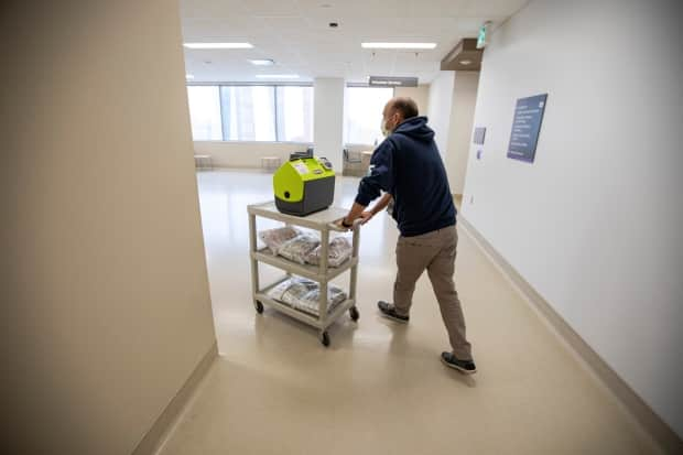 Vaccine team lead Ruben Rodriguez pushes a trolly of supplies, including doses of the Moderna COVID-19 vaccine, through Humber River Hospital on May 4.