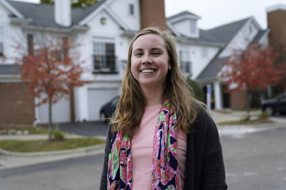 Ally Scully poses for a portrait outside her apartment building in Rochester, Mich., Wednesday, Oct. 14, 2020. Scully, 27, hesitantly voted for Donald Trump in 2016. She believes in traditional small-government Republican ideals like tax cuts and supporting small business. She prayed over her decision and walked into the booth still unsure. Now she thinks he earned her vote again. (AP Photo/Paul Sancya)