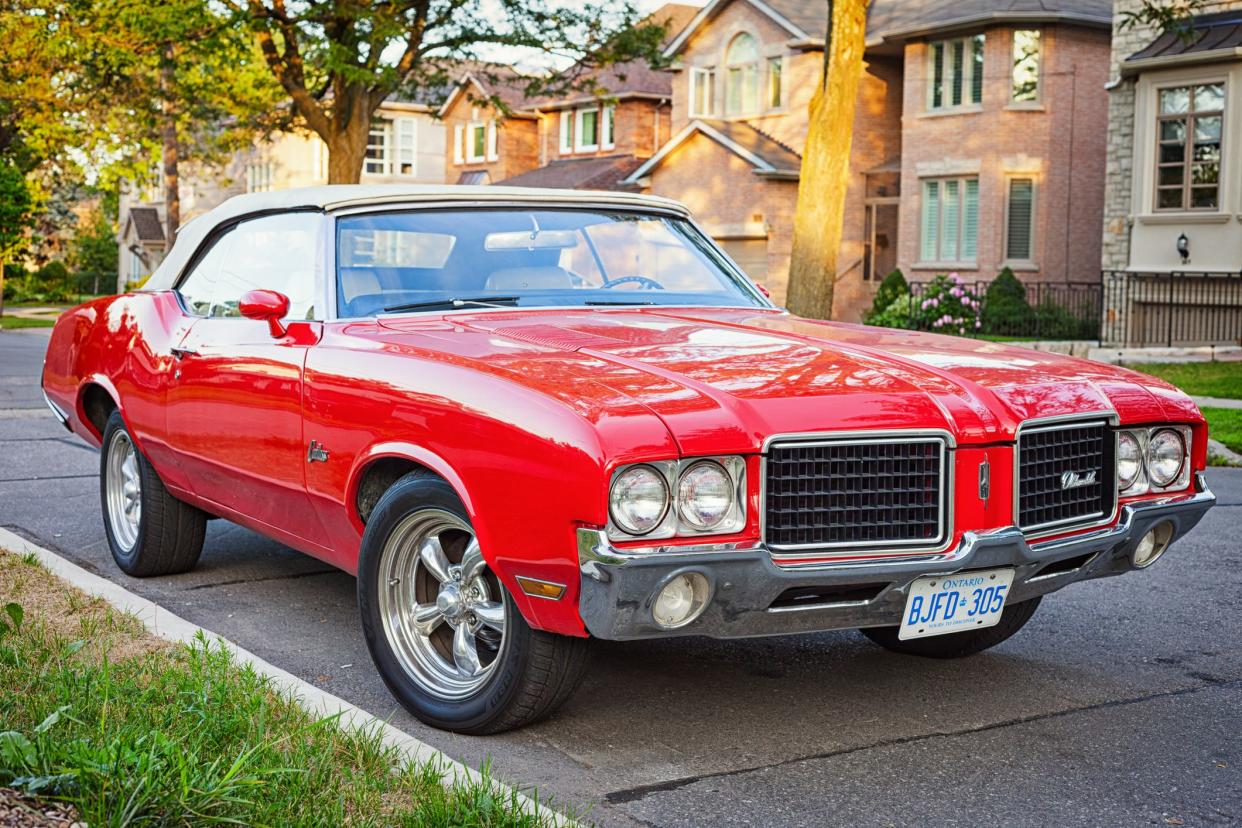 Toronto, Canada - August 4, 2011: A red colored, early 1970s Oldsmobile Cutlass convertible parked on a street in Toronto, Ontario.