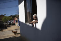 Eva Maria de Jesus, affectionately known as "Avo Eva" or Grandmother Eva, 110, looks from her home's window in the Rasa "Quilombo," comprised of people descended from runaway slaves, in Buzios, Brazil, Sunday, July 12, 2020. Despite being lucid, active, and still able to remember the songs and dances she learned from her parents who were once slaves, she still has not been told about her 78-year-old daughter Carivaldina Oliveira da Costa's death from COVID-19. (AP Photo/Silvia Izquierdo)