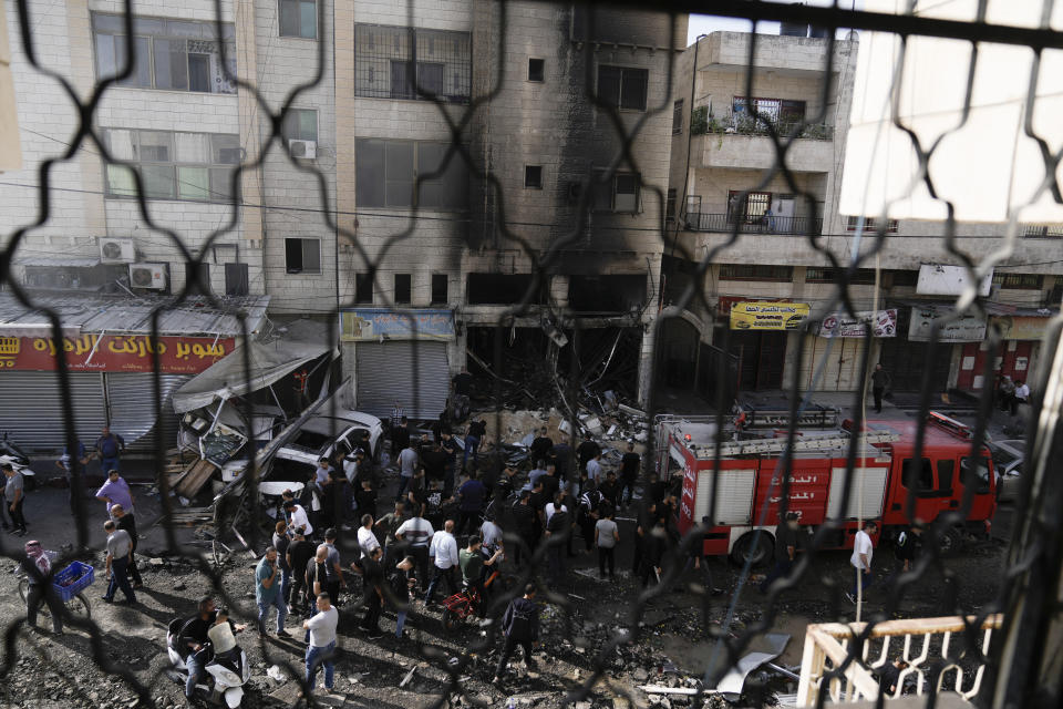 Palestinians stand by a shop destroyed in an Israeli raid in Jen refugee camp in the West Bank on Monday, Oct. 30, 2023. (AP Photo/Majdi Mohammed)