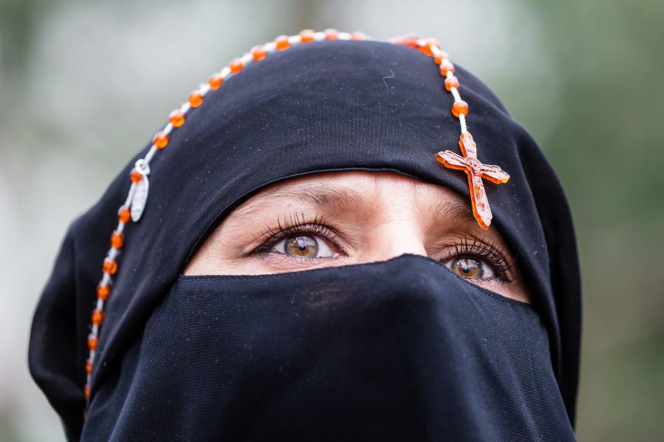 One woman protests in front of Polish parliament wearing her rosary beads.&nbsp;