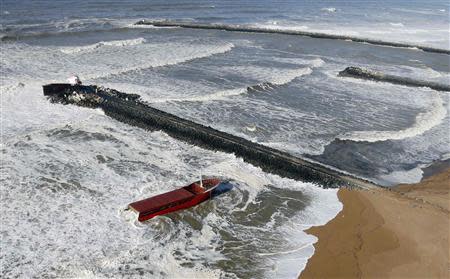 An aerial view show waves which break against a Spanish cargo ship carrying fertiliser, broken in two, off the beach in Anglet on the Atlantic Coast of France, February 5, 2014. REUTERS/Regis Duvignau