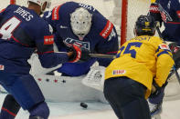 Unted States' goalkeeper Alex Lyon, center, makes a save in front of Sweden's Andre Burakovsky, right, during the preliminary round match between Sweden and United States at the Ice Hockey World Championships in Ostrava, Czech Republic, Friday, May 10, 2024. (AP Photo/Darko Vojinovic)