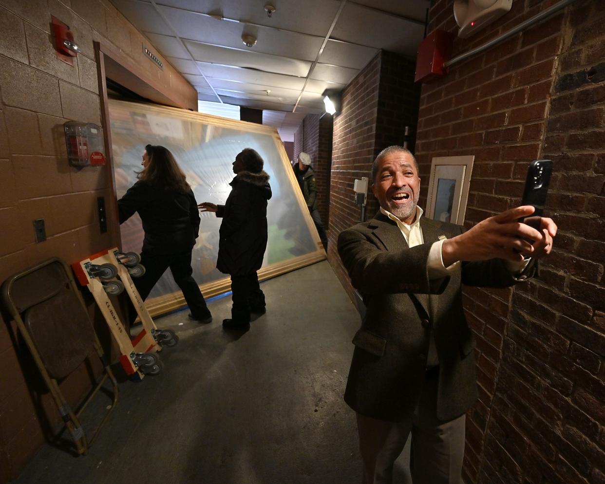 James Goldsberry — a descendant of 19th century Black Worcester business owners and abolitionists William Brown and Martha Brown — takes a selfie as workers struggle to load their approximately 11-by-8 foot portrait onto a freight elevator at Mechanics Hall. The workers ended up carrying the painting through the front doors.