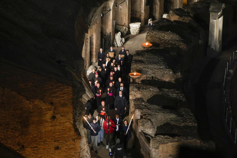 Faithful hold the cross as they take part in the Via Crucis (Way of the Cross) torchlight procession at the Colosseum on Good Friday, in Rome, Friday, April 7, 2023. The Vatican sayd Pope Francis won't go to the Colosseum for the traditional Good Friday procession but instead he will watch it from his home at the Vatican due to unseasonably cold nighttime temperatures in Rome. (AP Photo/Gregorio Borgia)