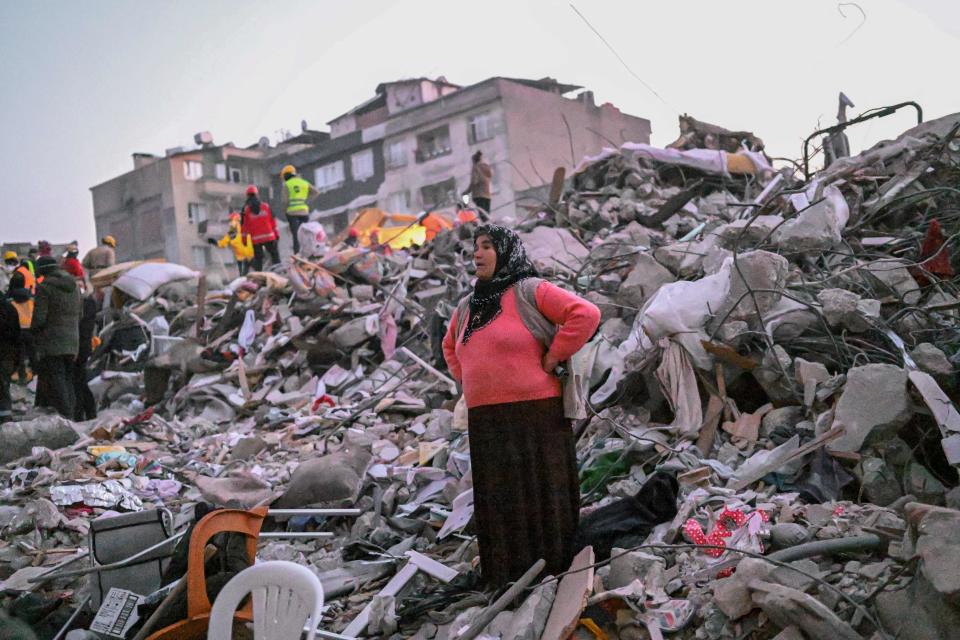 A woman stands in the rubble hoping her relatives to be found by rescuers in Hatay on February 13, 2023, as rescue teams began to wind down the search for survivors today, a week after an earthquake devastated parts of Turkey and Syria leaving more than 35,000 dead and millions in dire need of aid.