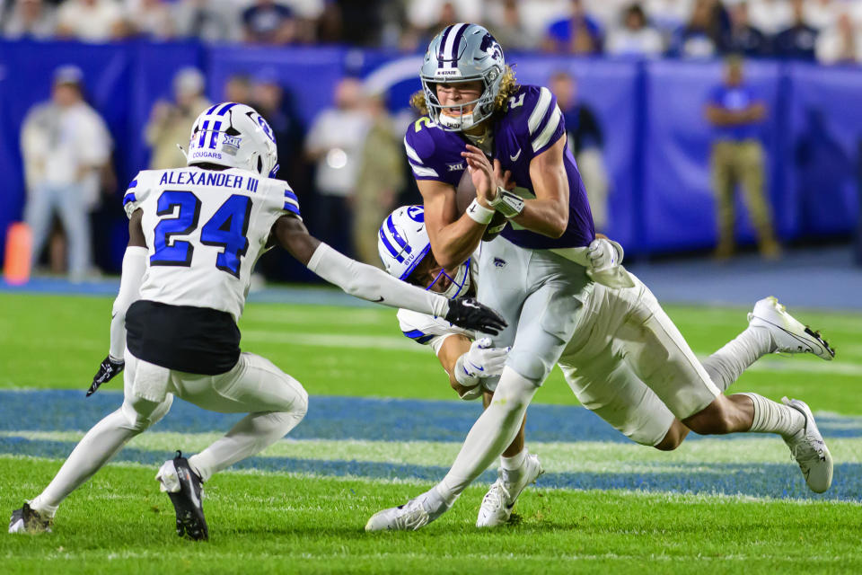 Kansas State quarterback Avery Johnson, center, is sacked by Brigham Young linebacker Jack Kelly, rear, and cornerback Therrian Alexander III (24) during an NCAA football game on Saturday, Sept. 21, 2024 in Provo, Utah. (AP Photo/Tyler Tate)