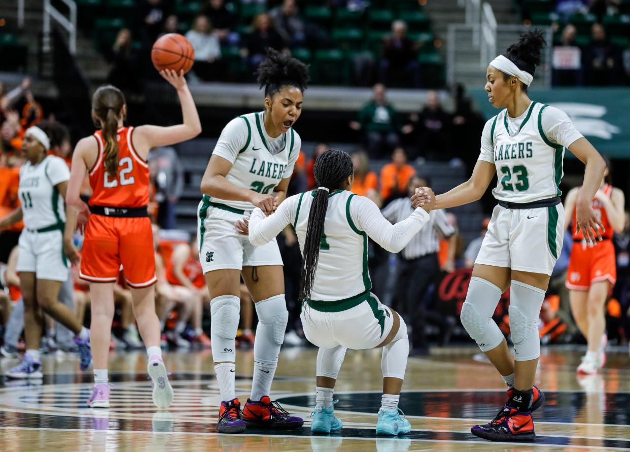 West Bloomfield guards Indya Davis (24) and Summer Davis (23) pick up guard Destiny Washington (1) from the floor after a play against Rockford during the second half of the MHSAA Division 1 girls basketball final at Breslin Center in East Lansing on Saturday, March 18, 2023.