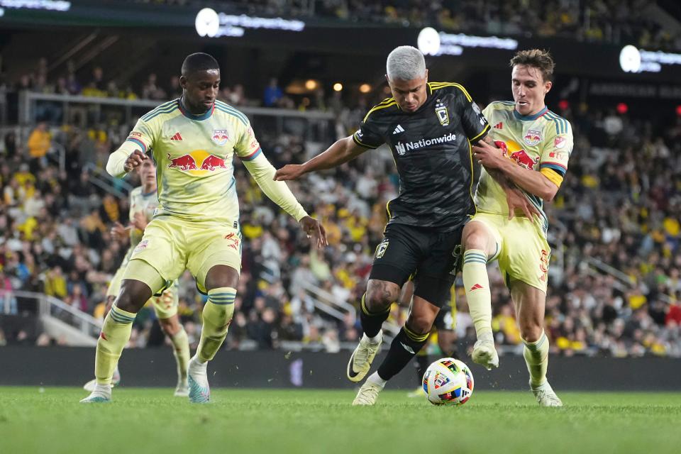 Crew forward Cucho Hernandez dribbles between the Red Bulls' Andres Reyes (4) and Peter Stroudndez on March 16.