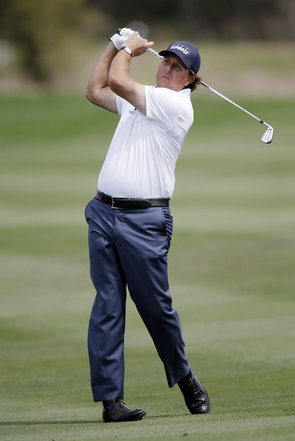 Phil Mickelson watches his fairway shot on the 14th hole during the third round of the Texas Open golf tournament, Saturday, March 29, 2014, in San Antonio. Mickelson withdrew from the tournament with a pulled muscle. (AP Photo/Eric Gay)