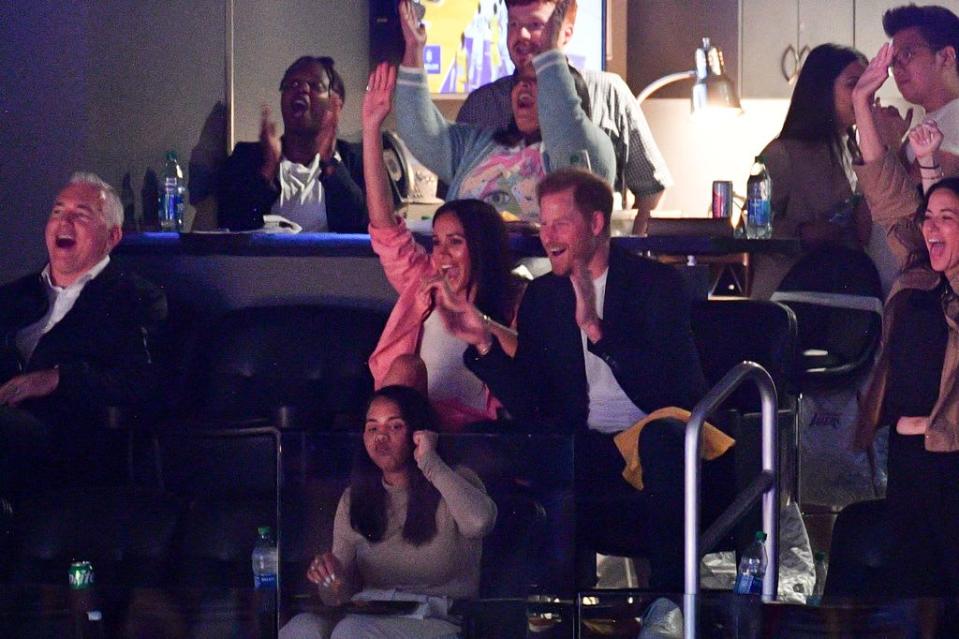 Meghan Markle and Prince Harry cheering during an NBA game