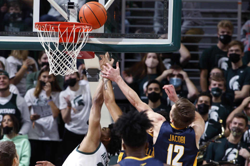 Michigan State's Jaden Akins, left, and Toledo's Ryan Rollins, center, and Kooper Jacobi (12) reach for a rebound during the first half of an NCAA college basketball game, Saturday, Dec. 4, 2021, in East Lansing, Mich. (AP Photo/Al Goldis)