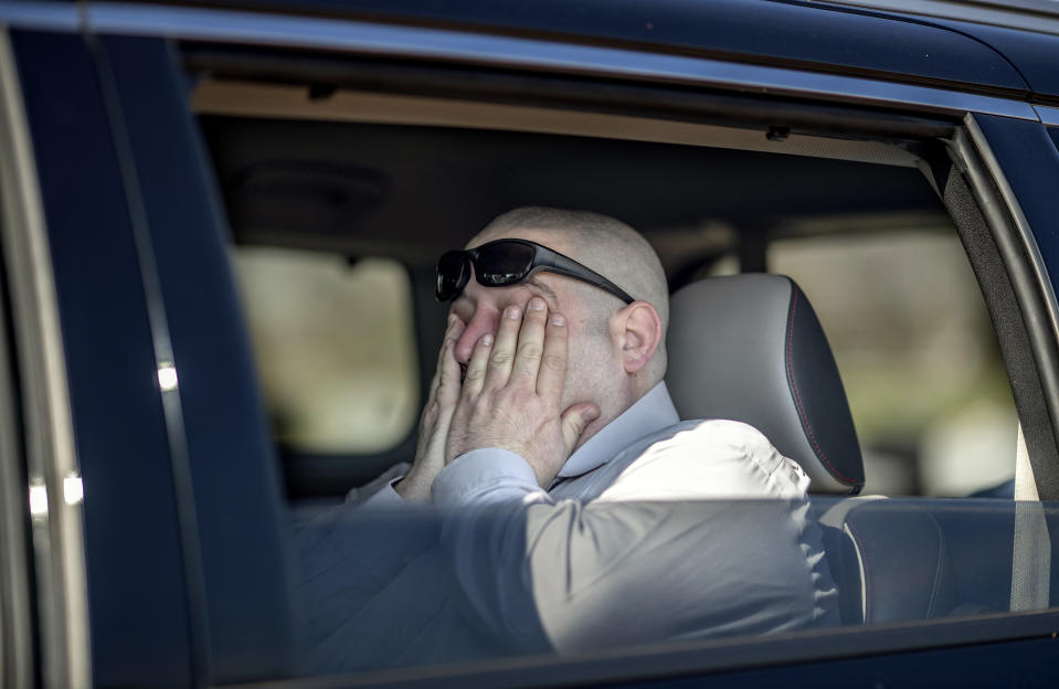 Jason Boxer wipes away tears while observing from the car the burial of his father, Allen Boxer, at Mount Richmond Cemetery in the Staten Island borough of New York, Sunday, April 12, 2020. "He was kind and gentle and had the biggest heart of anyone you'd know," said Boxer of his father, a U.S. Army veteran. "It's hard, very hard," he added of not being able to stand at the grave during the service. (AP Photo/David Goldman)