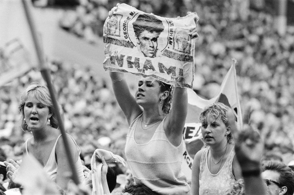 Fans enjoy Wham! The Farewell Concert at Wembley Stadium, London on 28th June 1986. Wham!, (singer George Michael, and singer/guitarist Andrew Ridgeley) played their final concert as Wham!, although Andrew joined George as a guest on a few later George Michael solo shows, 28th June 1986. (Photo by Alan Olley/Daily Mirror/Mirrorpix/Getty Images)