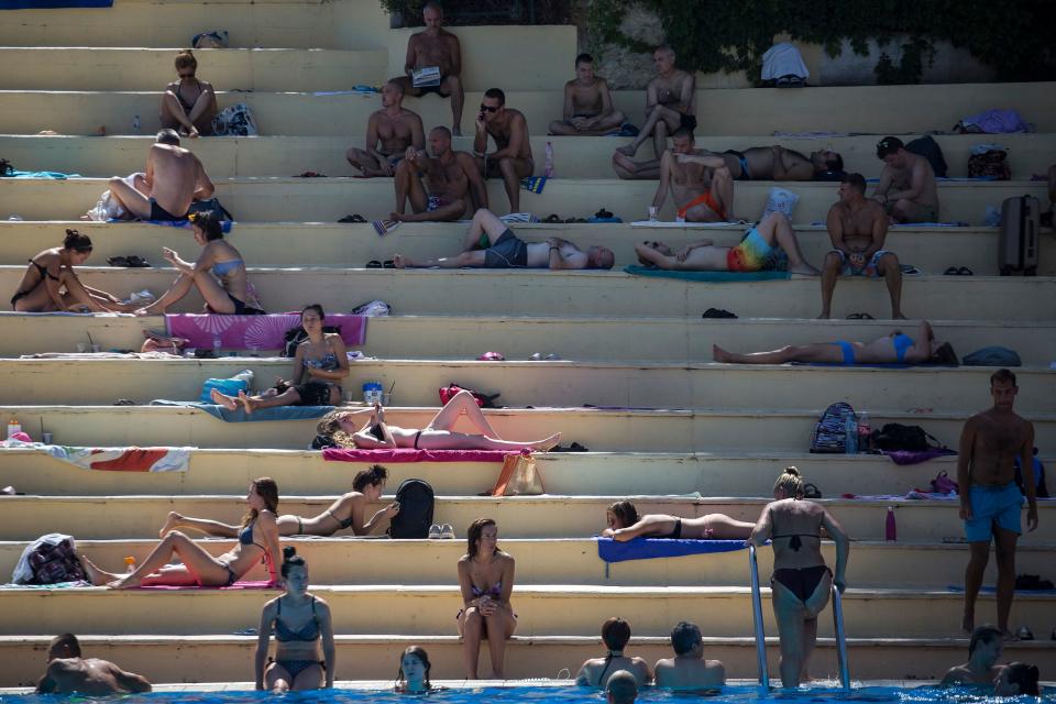 People cool off and sunbathe by swimming pool in Belgrade on August 12, 2019, as a new heatwave hits the Serbian capital. - According to weather forecasts, warm winds from northern Africa will affect Serbia with temperatures reaching 38 degrees Celsius. (Photo by Vladimir ZIVOJINOVIC / AFP)        (Photo credit should read VLADIMIR ZIVOJINOVIC/AFP/Getty Images)