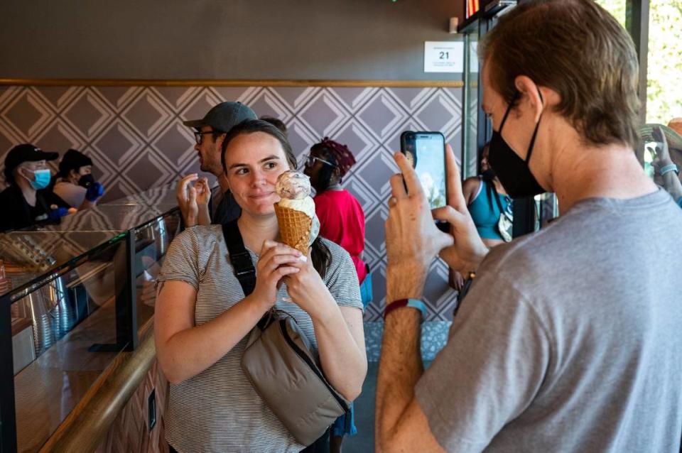 Sacramento resident Lauren Kolenda poses for boyfriend Avery Lay with her Salt & Straw ice cream – Arbequina olive oil and birthday cake with blackberry – on the shop’s opening day in midtown Sacramento in 2022.