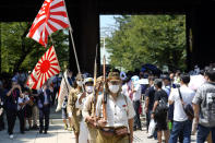 Visitors in Japanese Imperial army and navy uniforms walk near Yasukuni Shrine, which honors Japan's war dead, Saturday, Aug. 15, 2020, in Tokyo. Japan marked the 75th anniversary of the end of World War II. (AP Photo/Eugene Hoshiko)