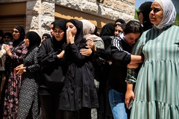 Mourners at the funeral of Israeli Arab Khalil Awaad and his daughter Nadine, 16, in the village of Dahmash near the Israeli city of Lod. A rocket fired from Gaza Strip hit their house and killed both.