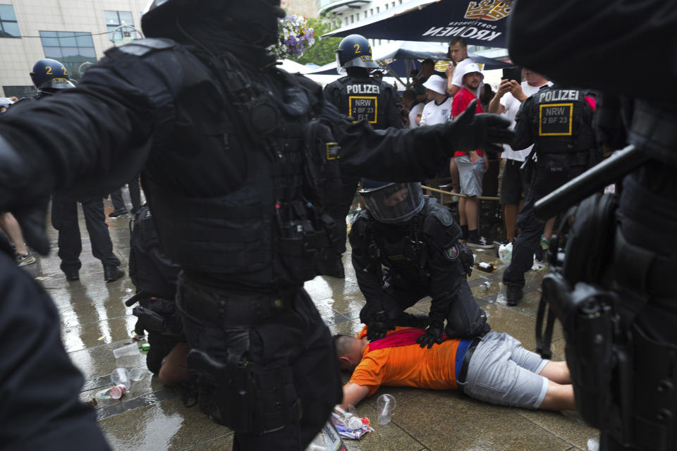 Police officers detain a soccer fan ahead of a semi final match between Netherlands and England at the Euro 2024 soccer tournament in Dortmund, Germany, Wednesday, July 10, 2024. (AP Photo/Markus Schreiber)