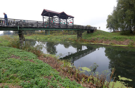 A man walks across the Andau bridge on the Hungarian-Austrian border, where a third of 200,000 refugees fled Hungary after an anti-Communist uprising was crushed by Soviet tanks in 1956, in Andau, Austria, October 20, 2016. REUTERS/Laszlo Balogh