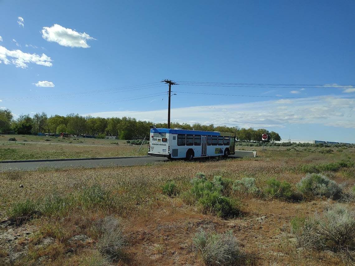 A Ben Franklin Transit bus uses a new pickup and turnaround loop on 2-acres of land donated by Amazon. The online mega retailer donated the property with improvements already completed near its new warehouses in Pasco. One of the warehouses is pictured in the distance.