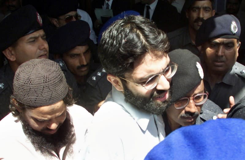 FILE PHOTO: British-born Islamic militant Ahmed Omar Saeed Sheikh (C) is surrounded by armed police as he leaves a court in Karachi on March 29, 2002