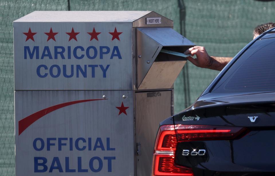 A voter drops their ballot into a drop box outside of the Maricopa County Tabulation and Election Center on Nov. 6, 2022 in Phoenix.