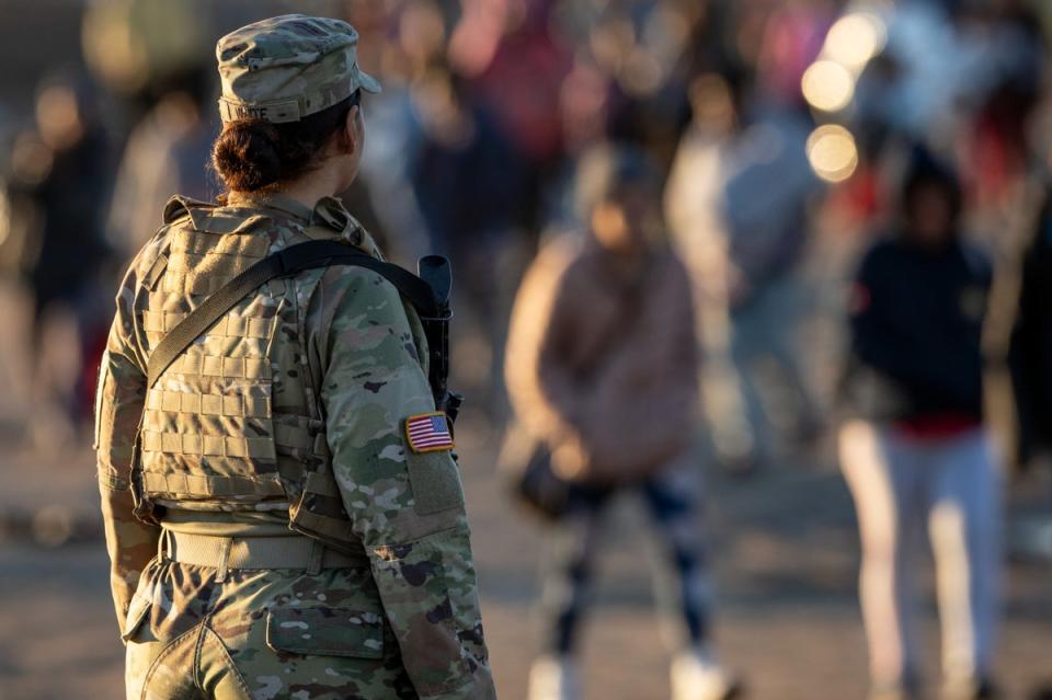 A Texas National Guard soldier observes as thousands of immigrants walk towards a U.S. Border Patrol transit center on December 19, 2023 (Getty Images)