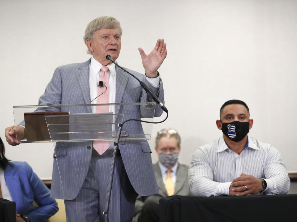 Houston Police officer Felipe Gallegos, right, listens as lawyer Rusty Hardin speaks during a press conference at Hilton Americas, Tuesday, Jan. 26, 2021, in Houston. Gallegos has been charged with murder and is among additional officers who have been indicted as part of an ongoing investigation into a Houston Police Department narcotics unit following a deadly 2019 drug raid, prosecutors announced Monday. (Karen Warren/Houston Chronicle via AP)
