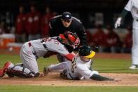 May 7, 2019; Oakland, CA, USA; Oakland Athletics right fielder Stephen Piscotty (25) slides into home for a run prior to the tag by Cincinnati Reds catcher Tucker Barnhart (16) during the second inning at Oakland Coliseum. Mandatory Credit: Stan Szeto-USA TODAY Sports