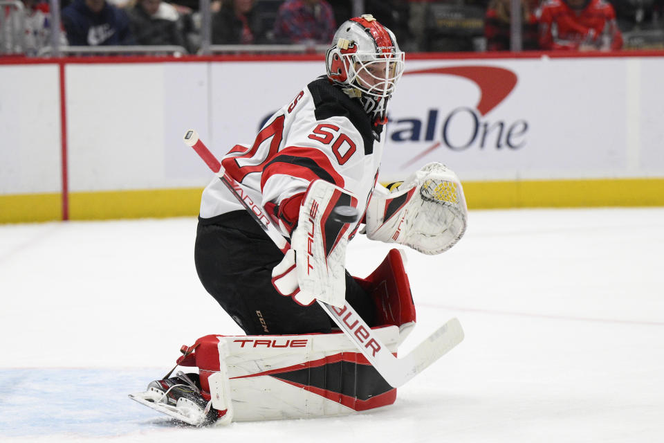 New Jersey Devils goaltender Nico Daws (50) watches the puck fly by during the first period of an NHL hockey game against the Washington Capitals, Saturday, March 26, 2022, in Washington. (AP Photo/Nick Wass)