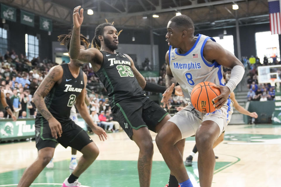 Tulane guard Jaylen Forbes (25) falls to the court as he is fouled by Memphis forward David Jones (8) during the first half of an NCAA college basketball game in New Orleans, Sunday, Jan. 21, 2024. (AP Photo/Gerald Herbert)