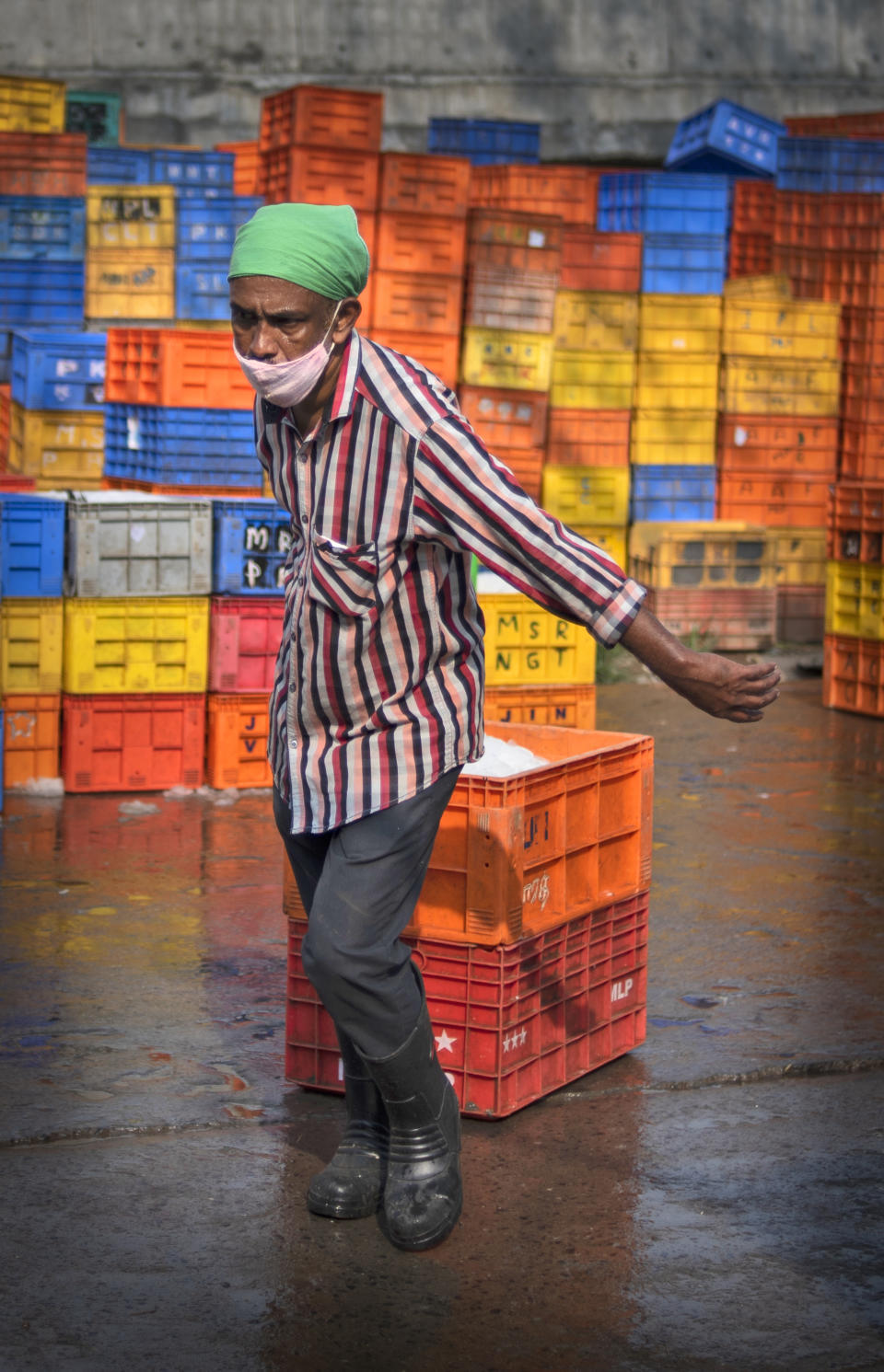 A man wearing mask as a precaution against the coronavirus works at a fish market in Kochi, Kerala state, India, Thursday, April 22, 2021. India reported a global record of more than 314,000 new infections Thursday as a grim coronavirus surge in the world's second-most populous country sends more and more sick people into a fragile health care system critically short of hospital beds and oxygen. (AP Photo/R S Iyer)