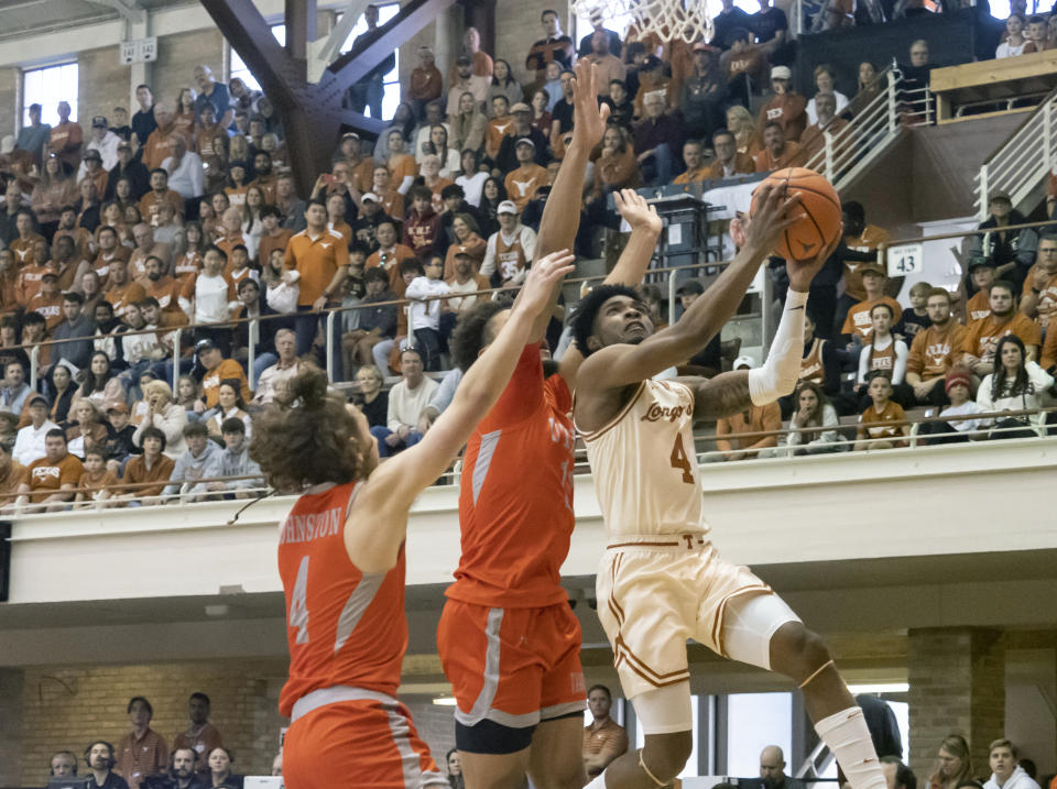 Texas guard Tyrese Hunter (4) goes up to shoot against Texas Rio Grande Valley guard Will Johnston (4) and forward Ahren Freeman (11) during the first half of an NCAA college basketball game Saturday, Nov. 26, 2022, in Austin, Texas. (AP Photo/Michael Thomas)