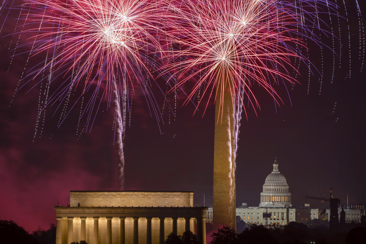 Fireworks light up the sky above the National Mall, with the Lincoln Memorial in view at the left and the U.S. Capitol building in view at the right, during an Independence Day celebration. 
