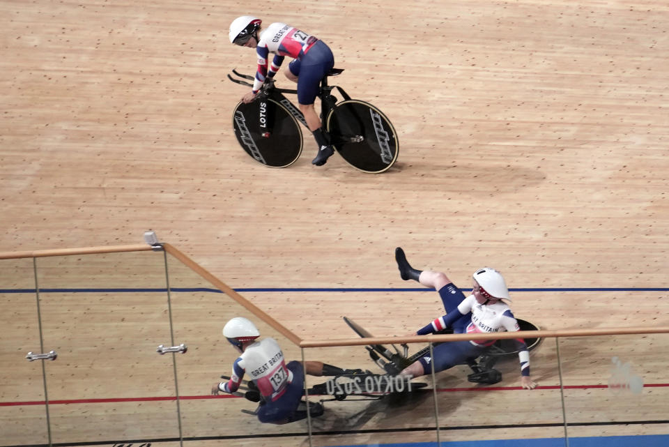 Laura Kenny of Team Britain (27) watches as Neah Evans (137) and another teammate crash as they compete during the track cycling women's team pursuit at the 2020 Summer Olympics, Tuesday, Aug. 3, 2021, in Izu, Japan. (AP Photo/Christophe Ena)