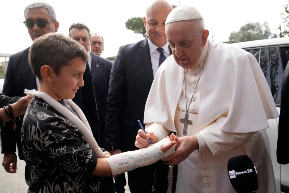 Pope Francis autographs the plaster cast of a child as he leaves the Agostino Gemelli University Hospital in Rome, Saturday, April 1, 2023, after receiving treatment for bronchitis, The Vatican said.