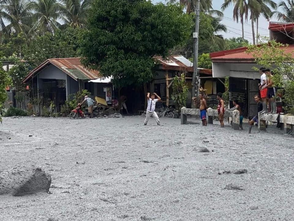 villagers wading through lahar from the eruption of Mount Kanlaon volcano at a village in the town of La Castellana (EPA)