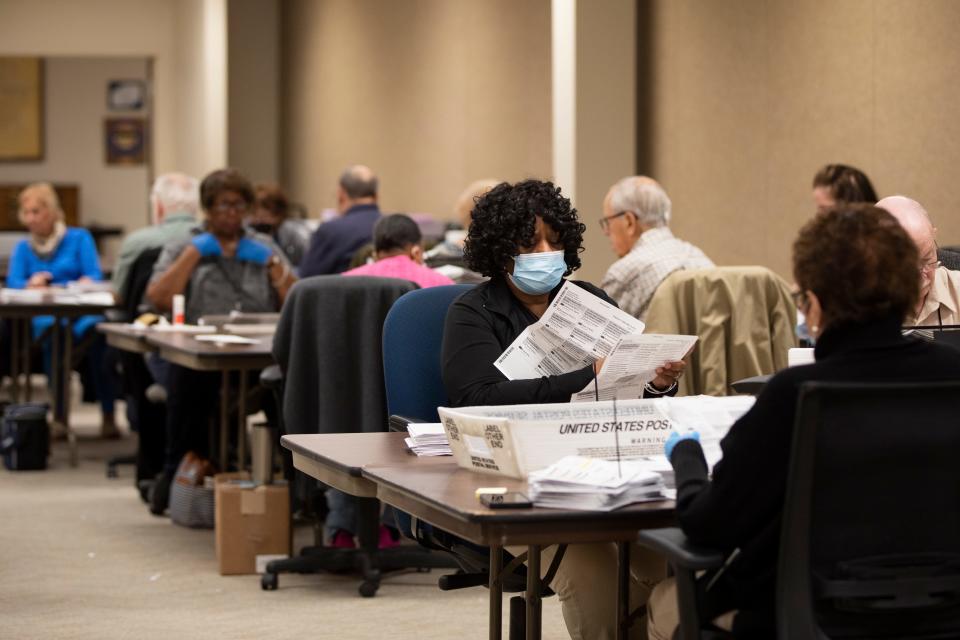 Employees of the Hamilton County Board of Elections sort through and examine absentee ballots to determine eligibility on Thursday, Nov. 3, 2022.