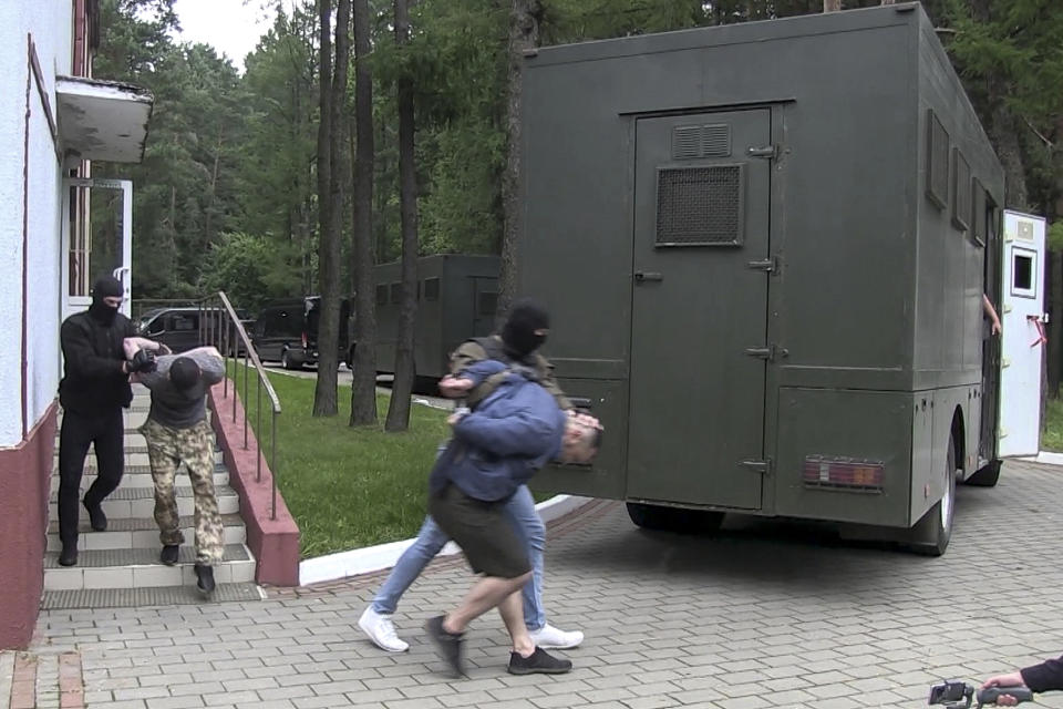 FILE In this file photo taken from video released by Belarusian KGB, State TV and Radio Company of Belarus on Wednesday, July 29, 2020, Belarusian KGB officers detain Russian men in a sanitarium outside in Minsk, Belarus. In what the opposition and many independent observers saw as Lukashenko's attempt to shore up sagging public support, Belarusian authorities arrested 33 Russian military contractors and charged them with plans to stage "mass riots. Belarus’ authoritarian President Alexander Lukashenko faces a perfect storm as he seeks a sixth term in the election held Sunday, Aug. 9, 2020 after 26 years in office. (Belarusian KGB, State TV and Radio Company of Belarus via AP, File)