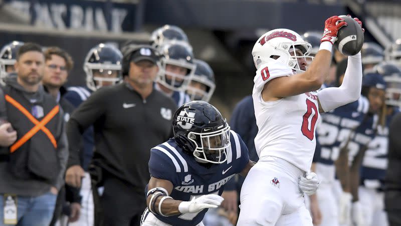 Fresno State wide receiver Mac Dalena (0) catches a pass as Utah State cornerback Xavion Steele defends during the first half of an NCAA college football game Friday, Oct. 13, 2023, in Logan, Utah. 