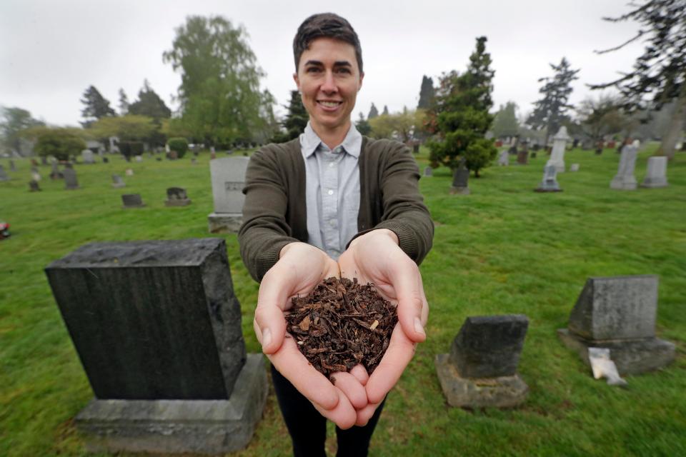 n this Friday, April 19, 2019, photo Katrina Spade, the founder and CEO of Recompose, displays a sample of the compost material left from the decomposition of a cow, using a combination of wood chips, alfalfa and straw, as she poses in a cemetery in Seattle. Washington  was the first state to allow the burial alternative known as "natural organic reduction," that turns a body into soil in a matter of weeks.