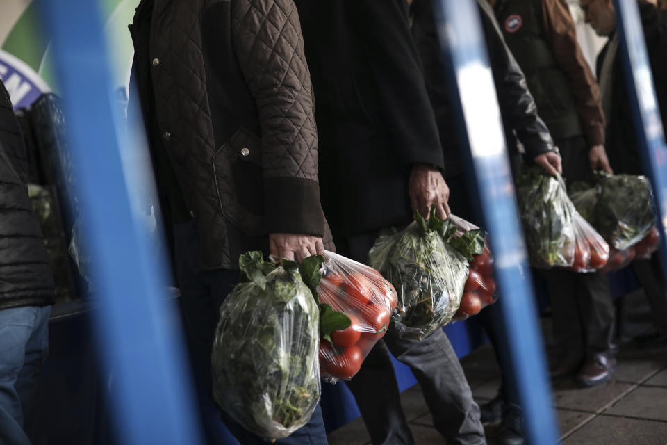 In this Sunday, Feb. 17, 2019 photo, shoppers wait in line to buy groceries at a government-run market selling spinach, tomatoes and peppers at discounted prices in an Istanbul neighbourhood. Turkey's President Recep Tayyip Erdogan's government has set up dozens of these temporary stalls in Turkey's largest cities in a bid to mitigate the effects of soaring food prices that have stung households. The move comes just over a month before Erdogan faces local elections on March 31, when runaway prices and an economic downturn could cost his ruling party some key municipal seats. (AP Photo/Emrah Gurel)