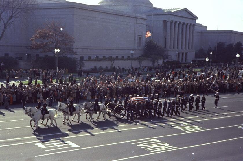 FILE - In this Nov. 25, 1963 file photo, the caisson bearing the flag-draped coffin of President John F. Kennedy moves in procession down Pennsylvania Avenue, in Washington, en route to Arlington National Cemetery. Kennedy's funeral was attended by "28 presidents, prime ministers and kings." As the horse-drawn coffin moved through Washington, "streets were lined by hundreds of thousands of people, many of them weeping." (AP File Photo)