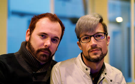 Gay married couple Charlie Craig (L) and David Mullins pose for a photo in their home in Denver, Colorado, U.S. November 28, 2017. Photo taken November 28, 2017. REUTERS/Rick Wilking